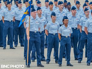 Air Force flight formation with guidon bearer and trainees at attention during a graduation ceremony at Lackland AFB.