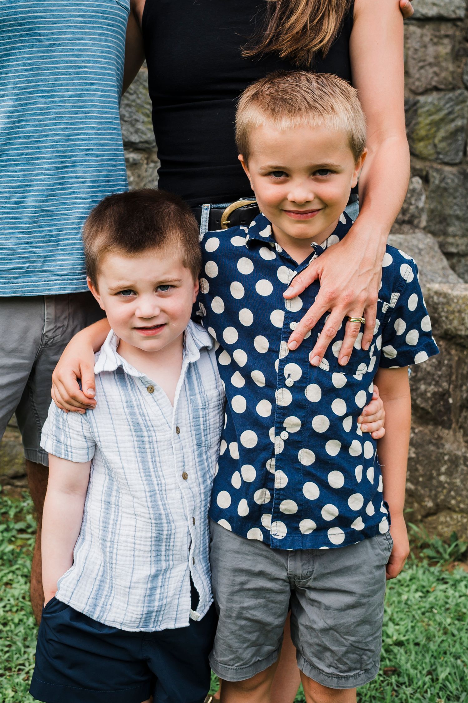 Four images in sequence show a young child posing with an adult's supportive hand in a casual outdoor setting.