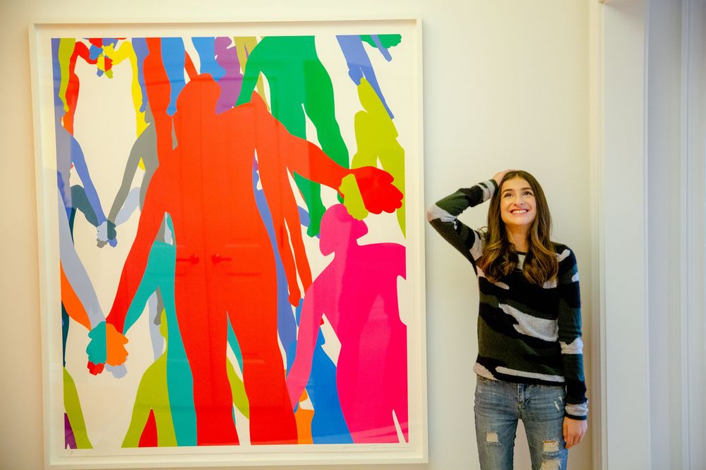 Colorful abstract art pieces displayed on a gallery wall create a vibrant atmosphere.