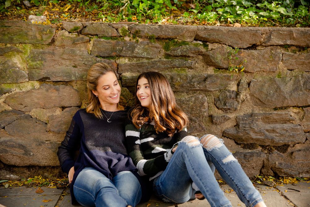 Couple sitting together on rustic stone steps surrounded by green foliage.