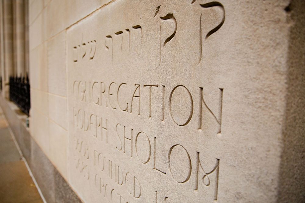 Stone wall with carved text detail showing classical architectural elements.