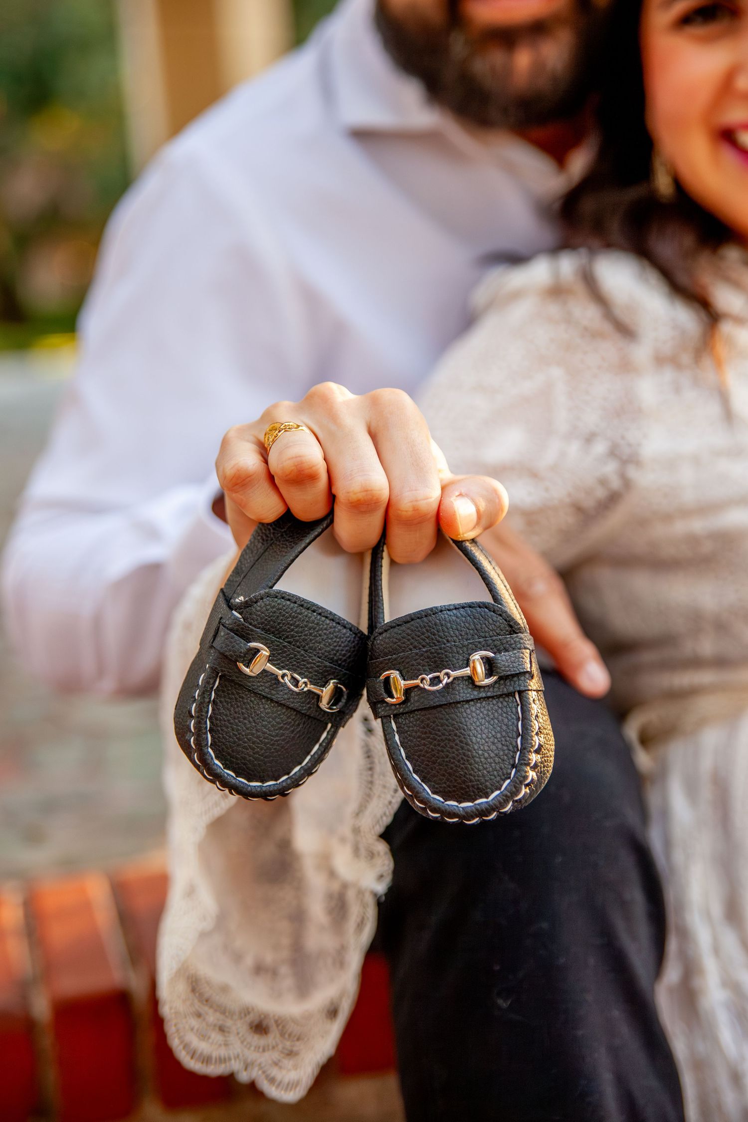 Mom and dad hold soon to be baby shoes at Dallas Texas park portrait maternity session