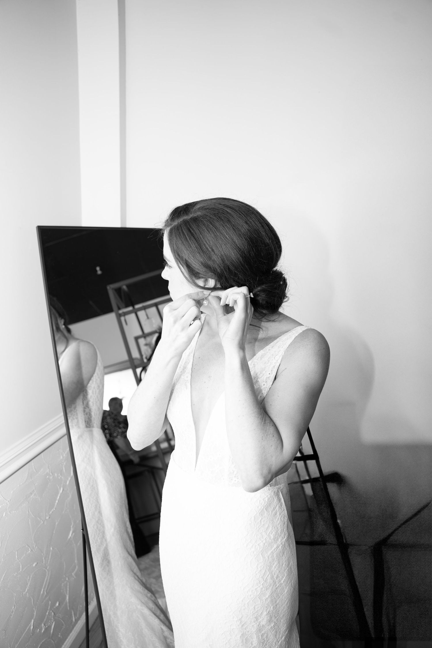 An emotional moment captured in black and white as a person in a white wedding dress wipes away tears.
