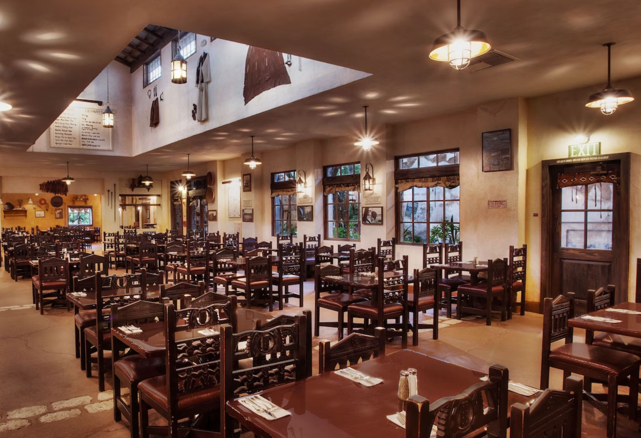 Interior dining room of Tusker House Restaurant with wooden tables and chairs in a rustic African-inspired setting.