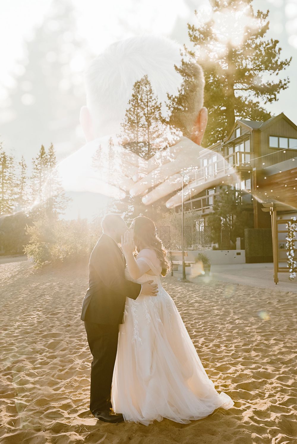 A couple shares their first dance on a sandy beach at sunset with a rustic lodge and pine trees in the background.