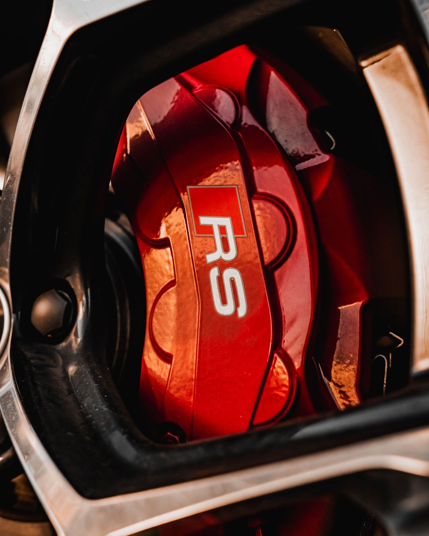 Close-up detail of a red RS performance brake caliper visible through a wheel.