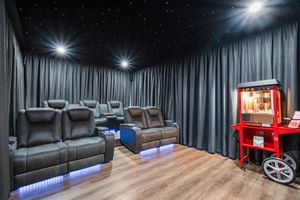 Home theater room with reclining seats, starlit ceiling and vintage popcorn machine.
