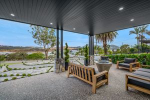 Covered patio with wooden furniture offering scenic mountain and landscape views.