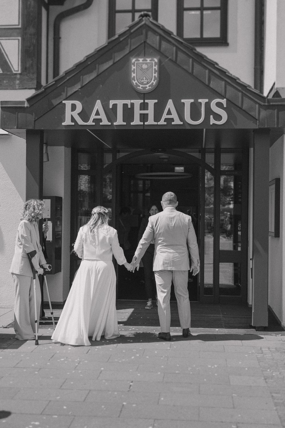 A couple entering the historic Rathaus building through its traditional doorway marked with a town crest above.