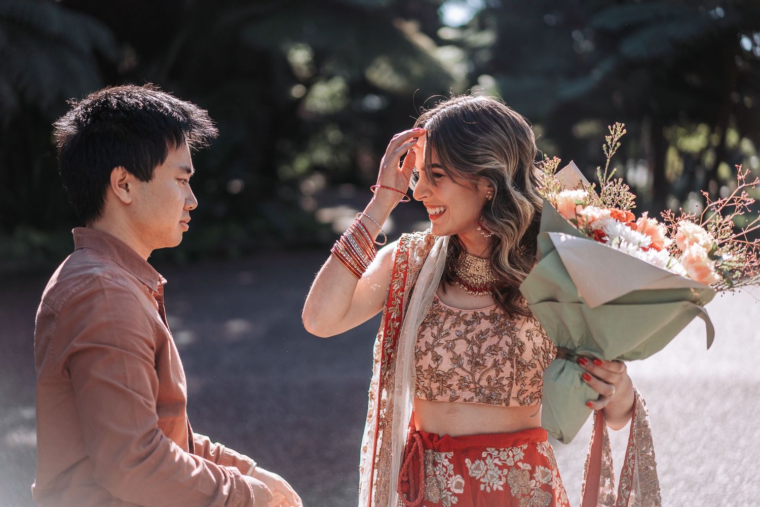 A romantic outdoor moment as someone receives a beautiful bouquet of flowers in soft sunlight.
