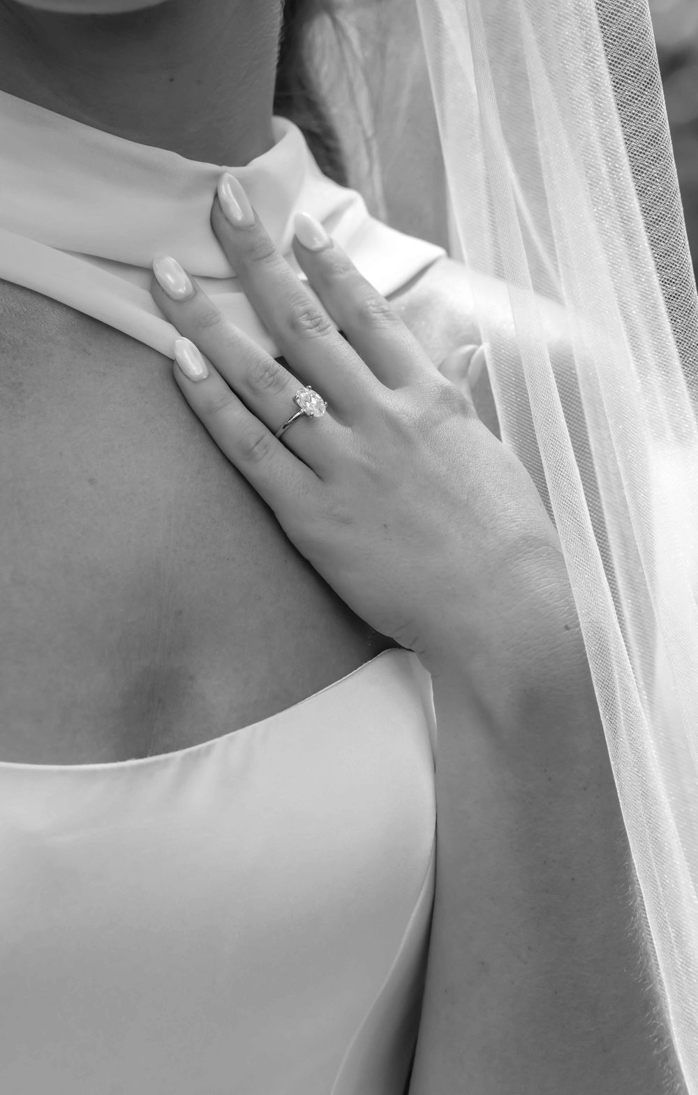 Close-up black and white photography sequence showing an engagement ring displayed on a hand against light fabric.