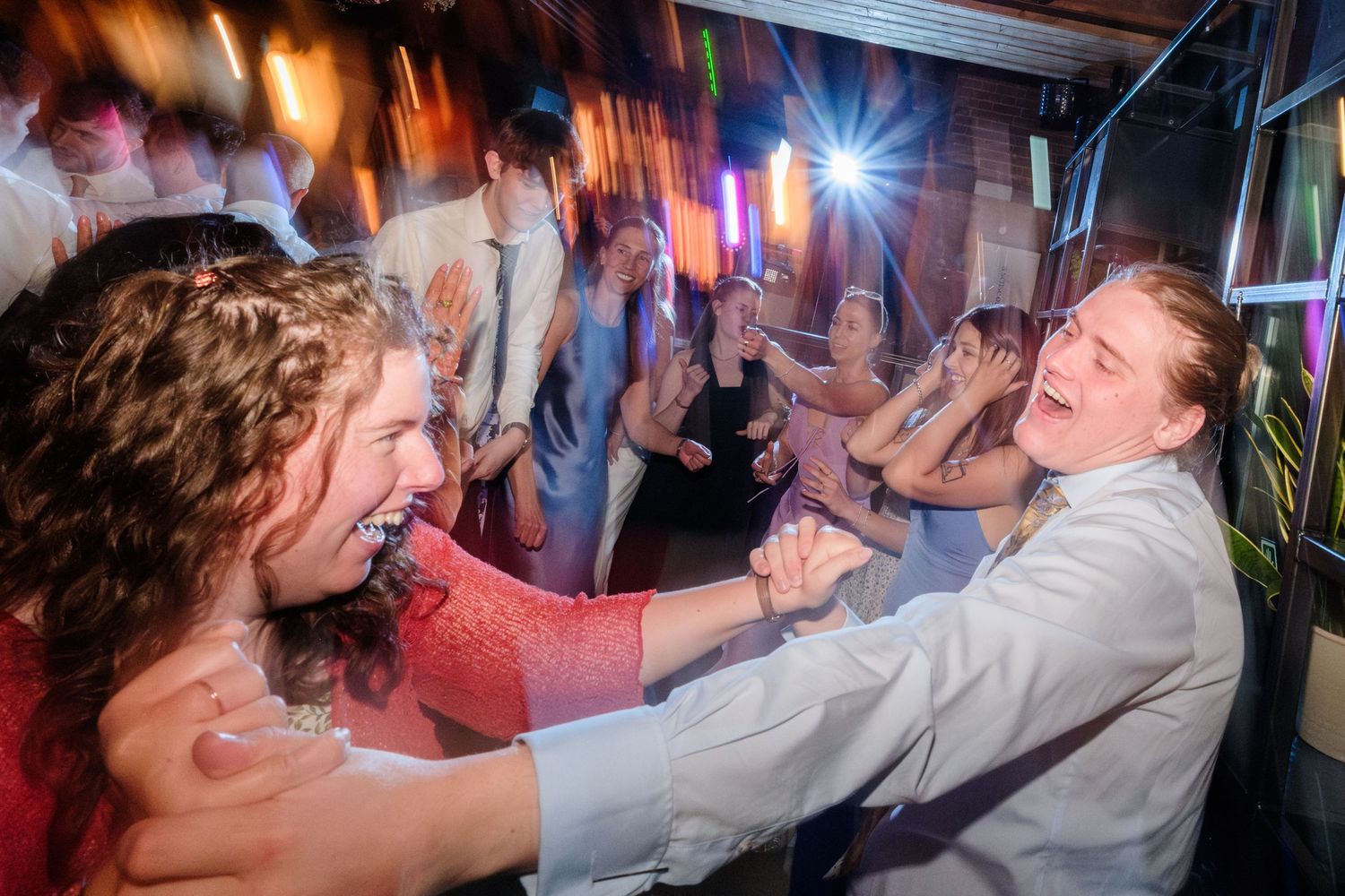 Dancers enjoying an energetic moment at a nightclub with colorful lighting and motion blur effects.