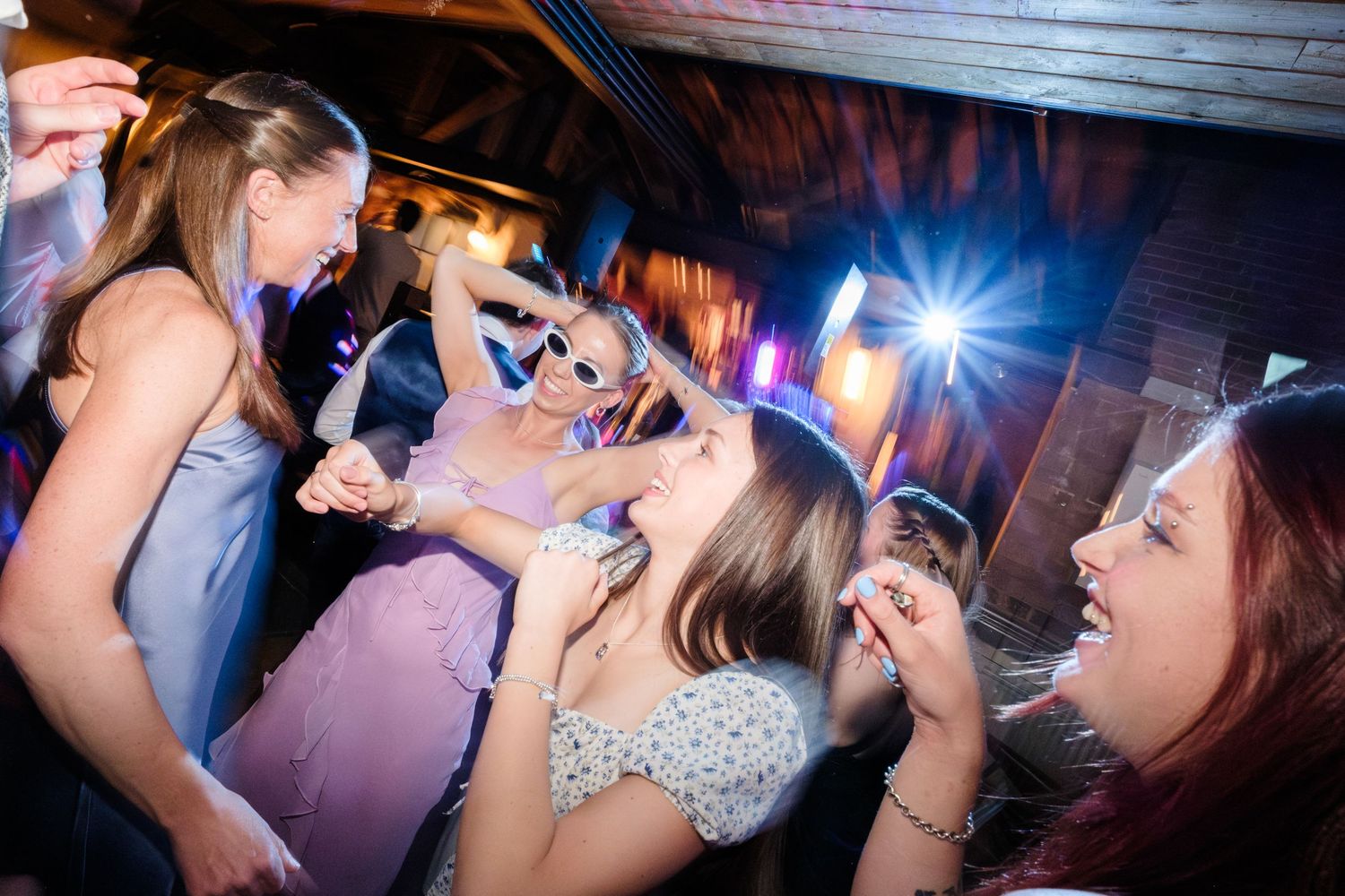 A lively party scene shows dancing people enjoying drinks and flashing lights at a nightclub.