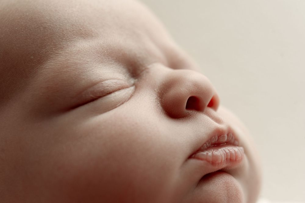 Close-up portrait of a peaceful sleeping newborn baby with soft skin and delicate features.