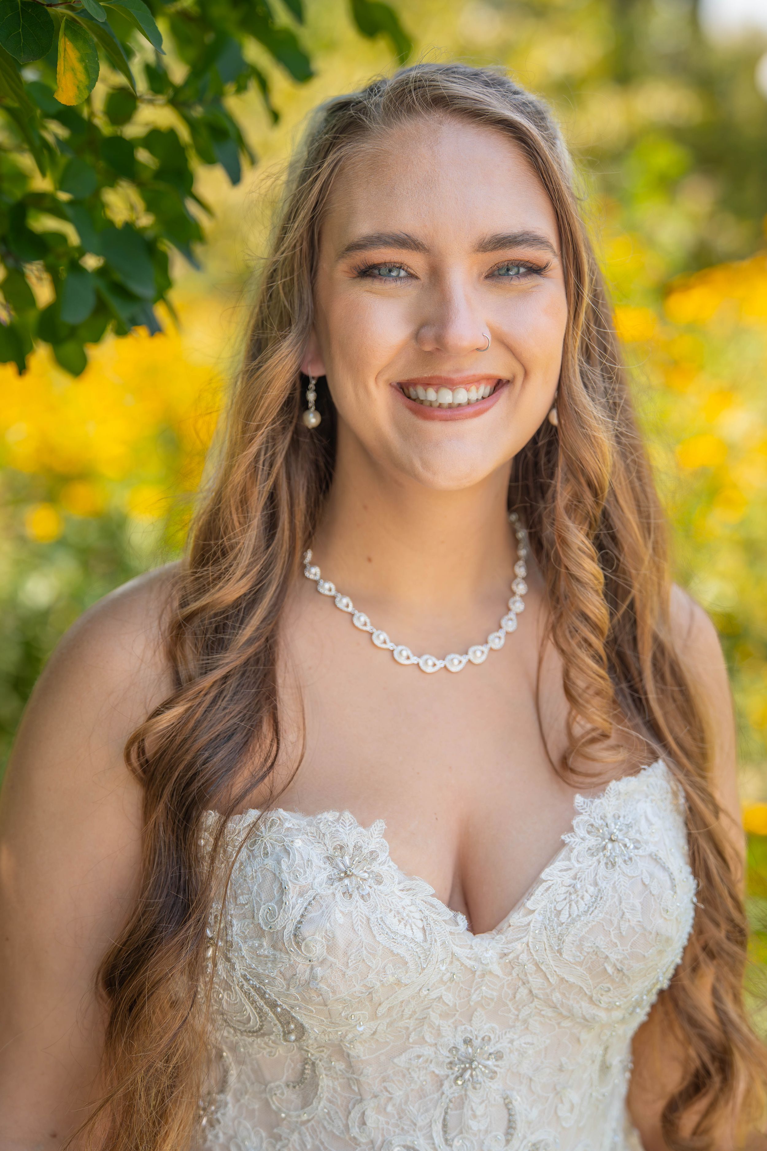 Close-up portrait shots outdoors with lush green foliage and yellow flowers in background.