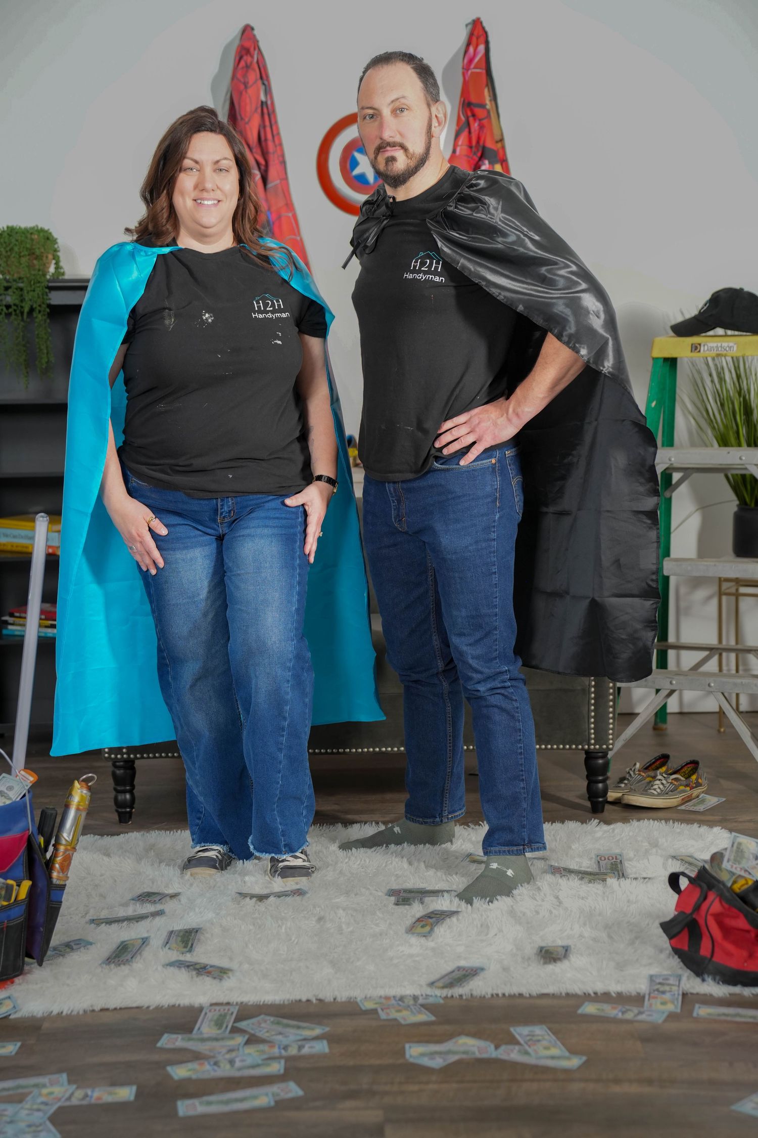 Professional portrait of a person in a black leather jacket and dress sitting on wooden floor with a warm smile.