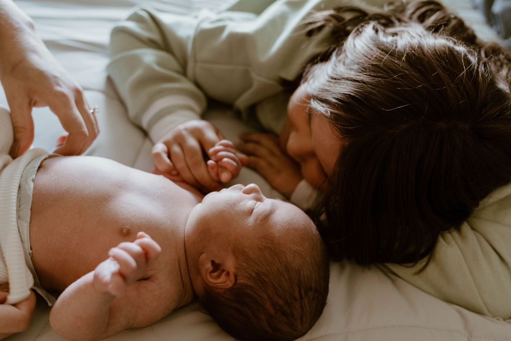 Close-up black and white portrait capturing a peaceful moment with a newborn.