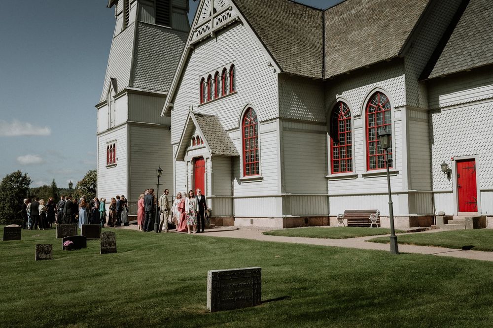 Bjurbäcks kyrka, Mullsjö. Kyrkan ör ljust grå och har röda dörrar.