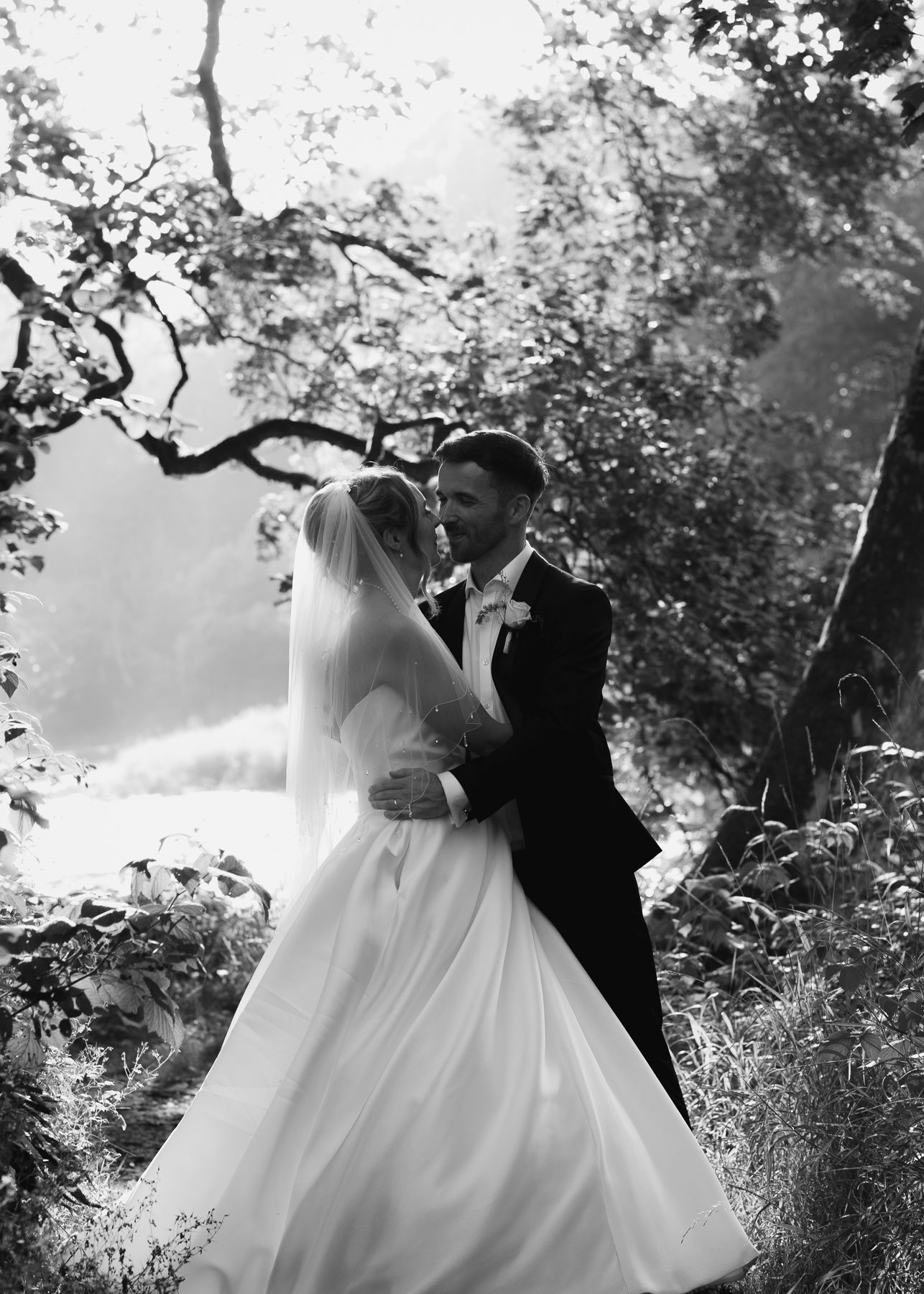 Black and white wedding photo series showing a couple sharing romantic moments in a garden setting.