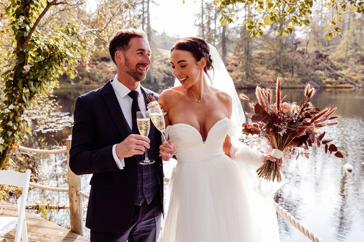 Bride and groom just married at Gilpin Hotel and Lake House, cheers with champagne by the Lake House