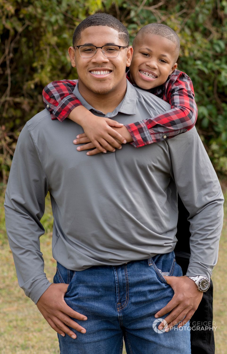 Brothers hugging during outdoor photos, documentary style.