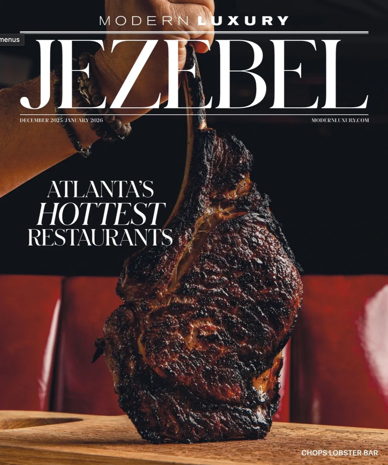 A large charred steak on a wooden board featured on the cover of Modern Luxury Jezebel magazine.