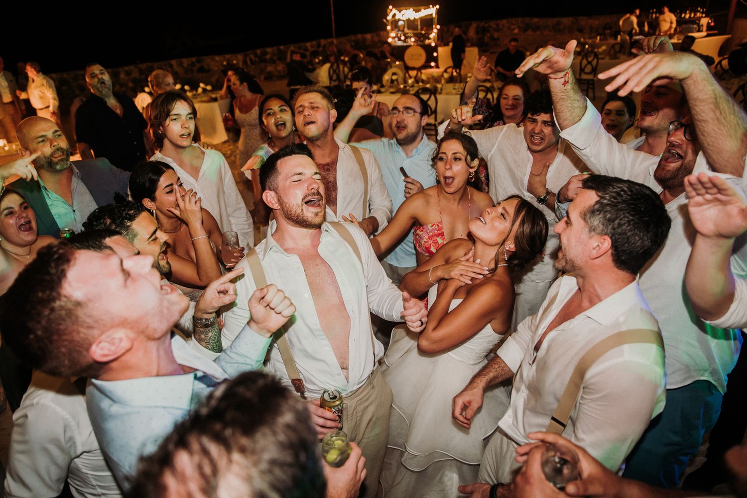 Reception guests dancing and celebrating on a crowded dance floor during an energetic party moment. El Dorado Royale Wedding Photographer