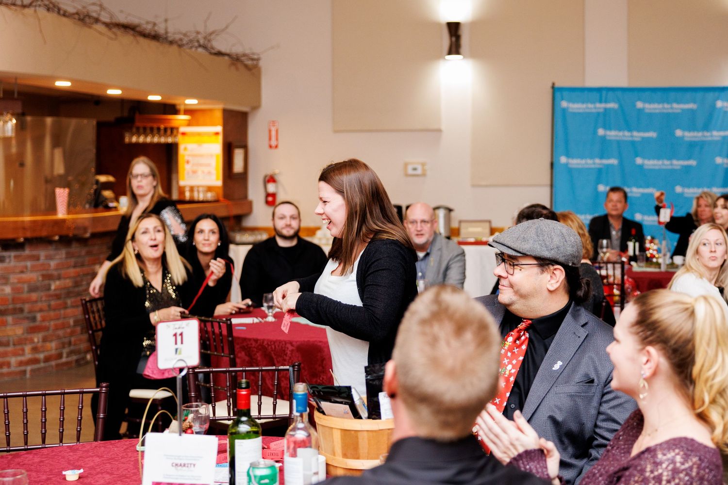 Business professionals networking and socializing at a corporate event in a warmly lit indoor venue.