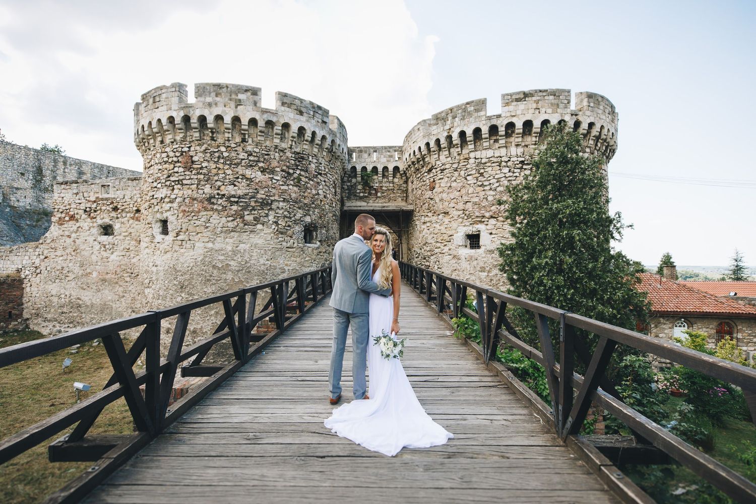 A panoramic view of ancient castle walls with a wooden walkway and stone fortifications in the background.