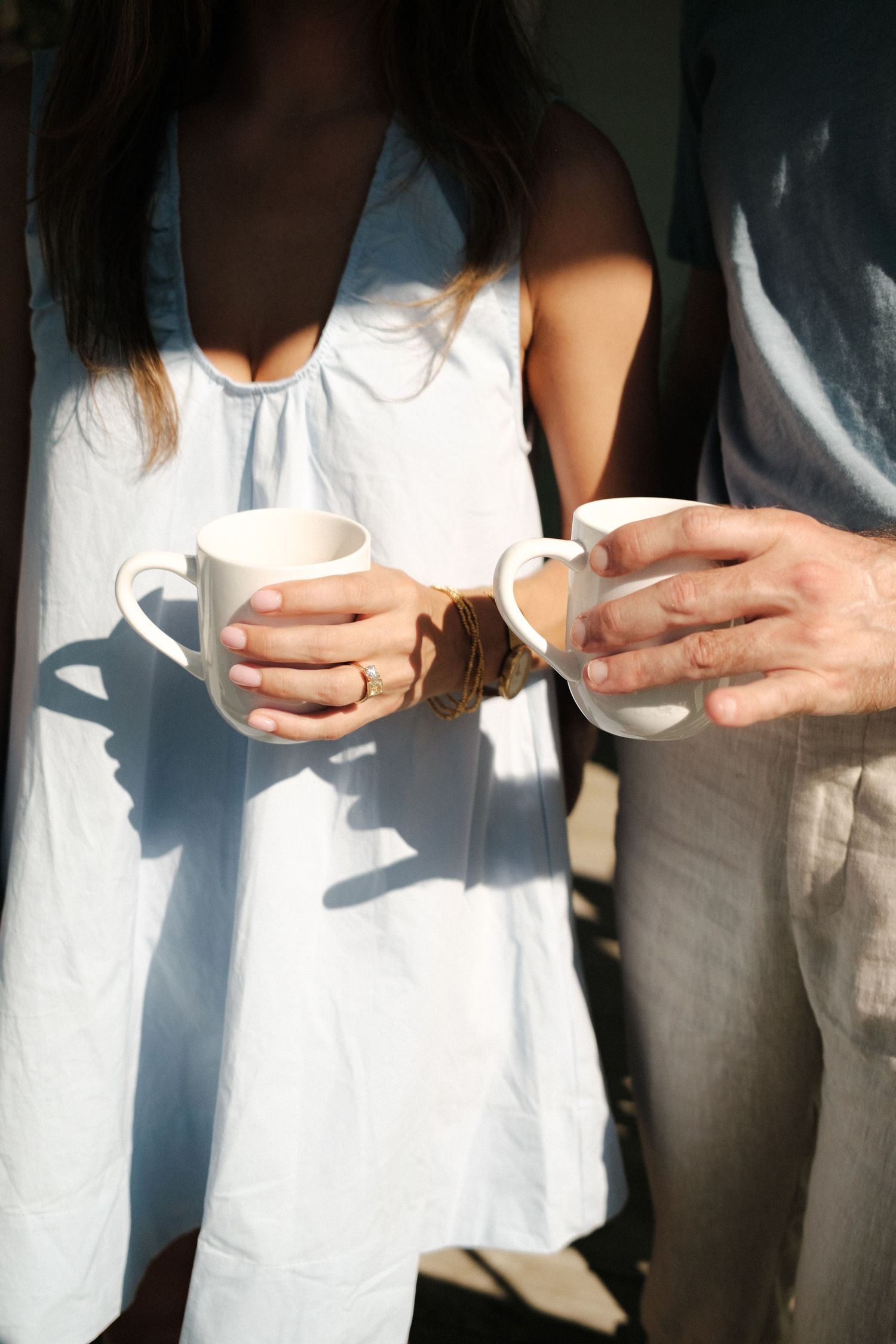 A romantic moment between a couple in white and khaki outfits on a lawn.