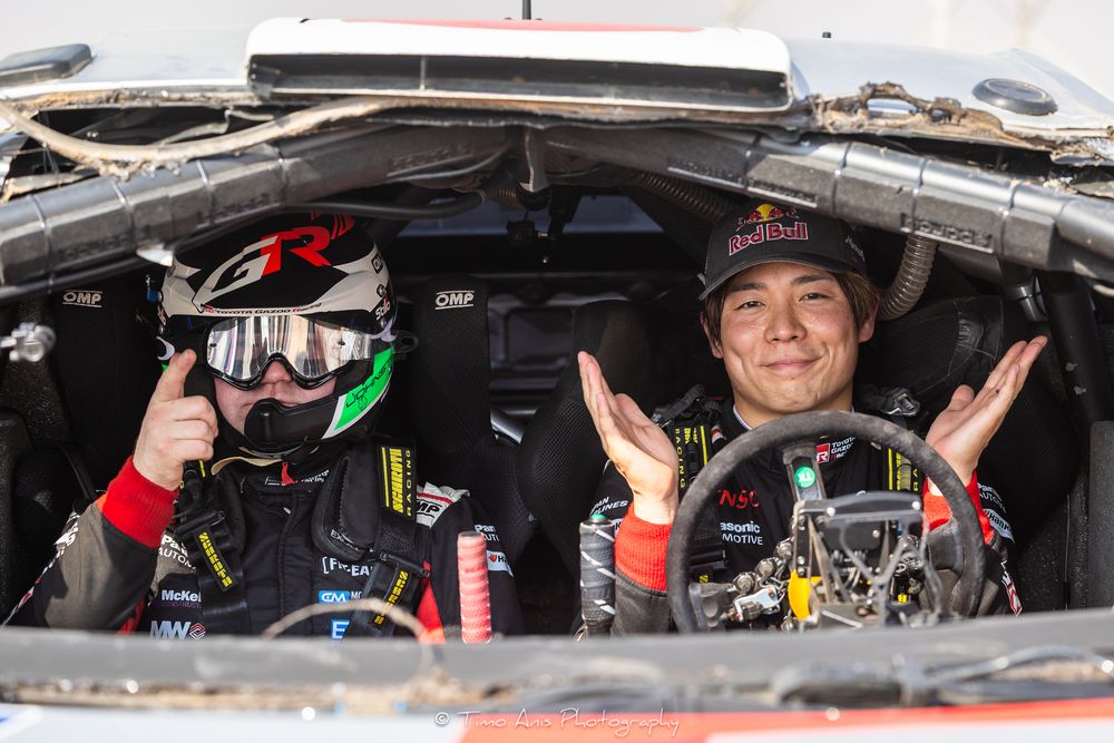 Race car driver inside cockpit of NASCAR vehicle during racing event at speedway track.