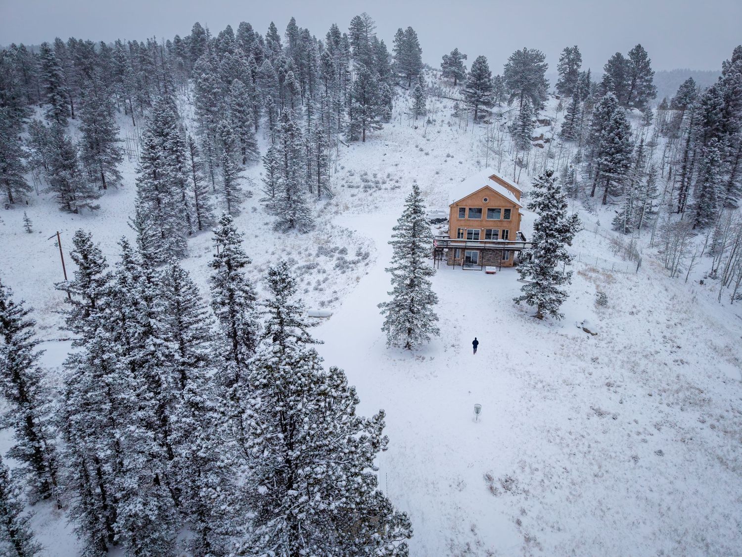 Aerial/drone photo of an AirBnb property in the snow