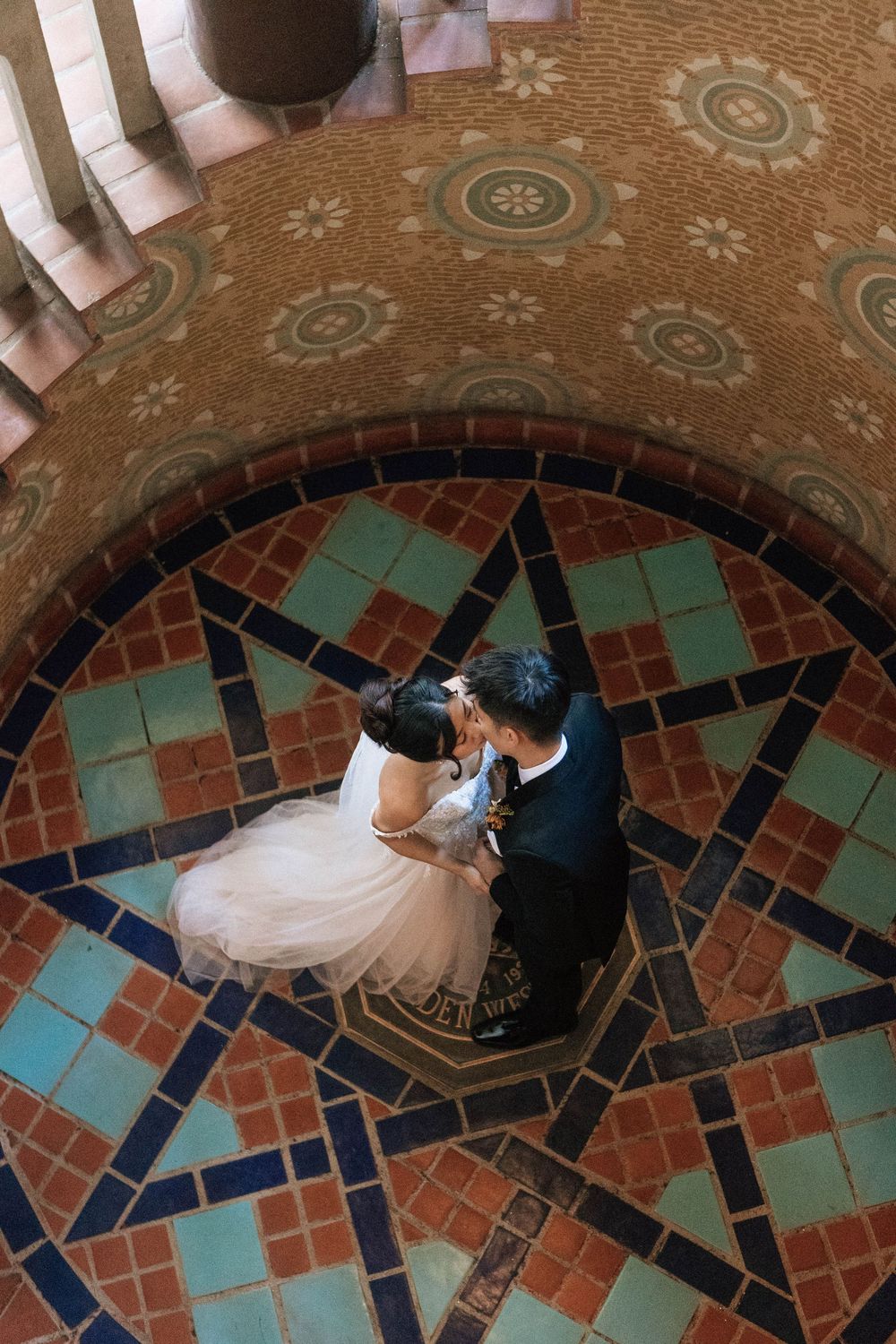 A Santa Barbara film photographer captures an editorial shot of a couple from above on the Santa Barbara Courthouse staircase
