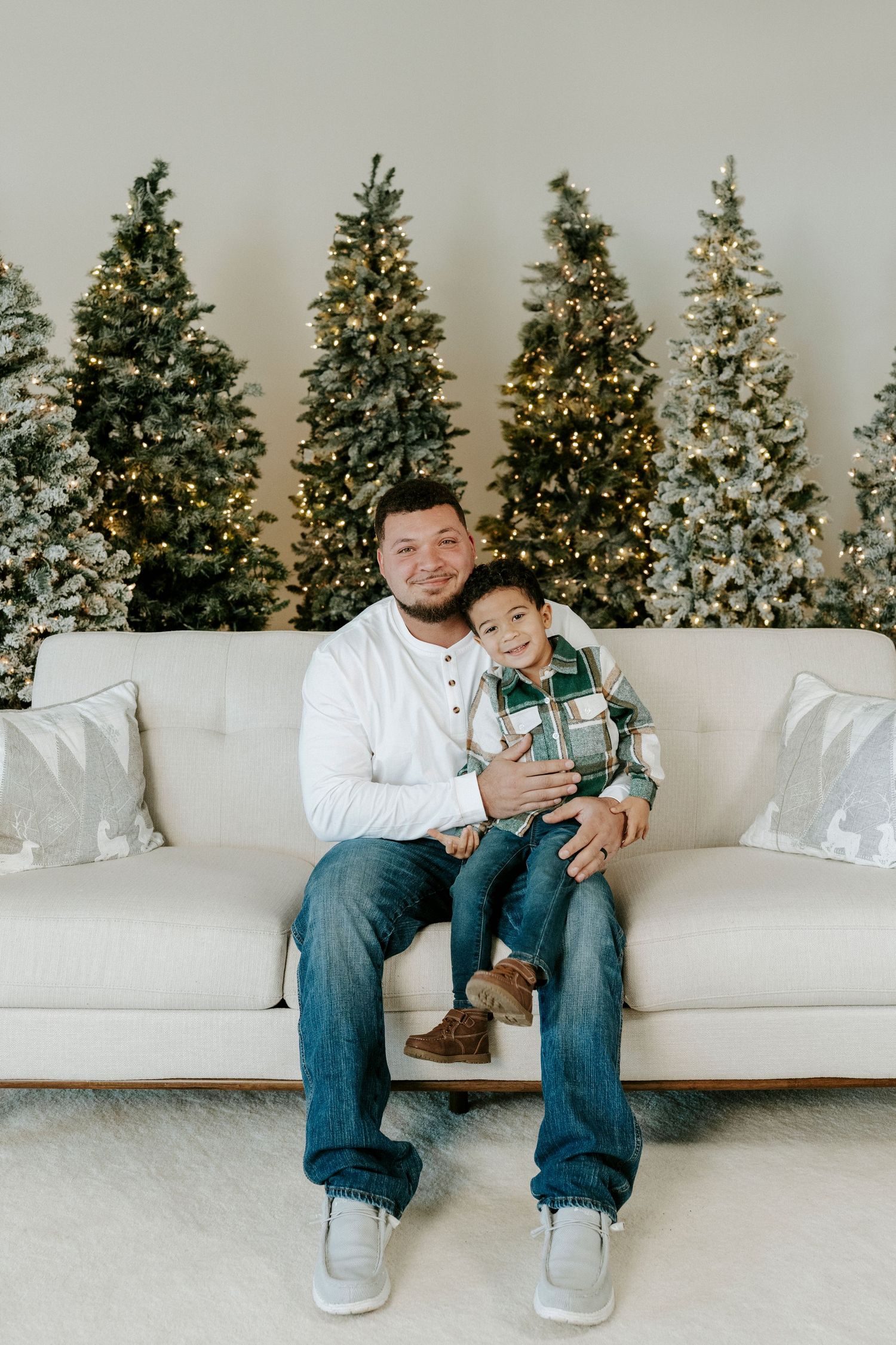 Three connected photos showing a white couch with Christmas trees decorated with lights in the background.
