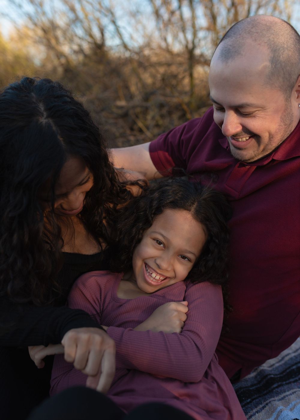 A joyful family moment captured outdoors during sunset with natural expressions.