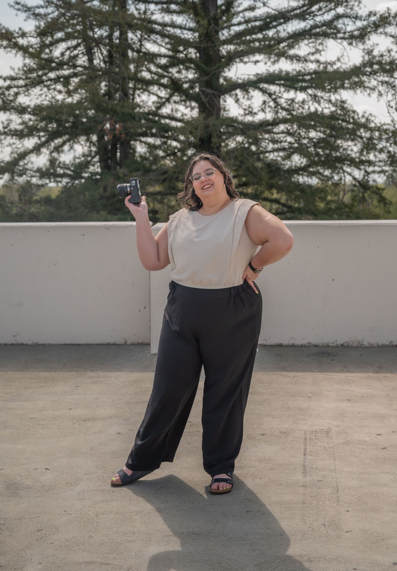 A person in dark pants and light shirt performs a series of dance moves on a concrete surface outdoors.