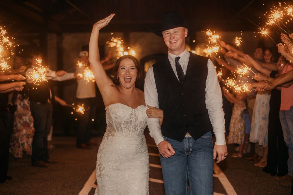 Wedding guests dance with sparklers during an evening celebration creating magical light trails in the darkness.