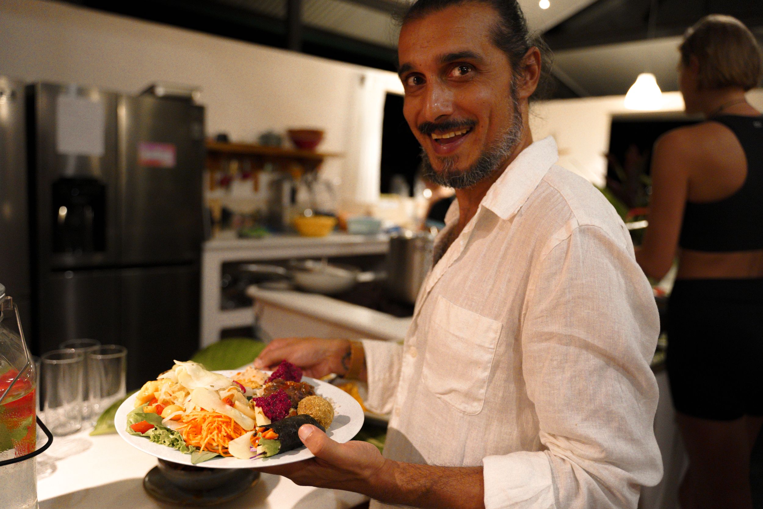 Person enjoying a colorful dinner plate in modern kitchen setting.