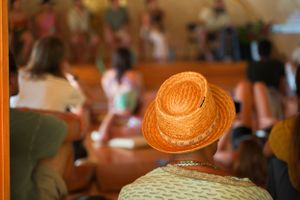 View of straw hat against crowd during indoor gathering.