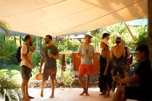 People gathered under outdoor canopy during daytime event.