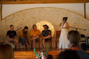 Performance taking place on stage in wooden dome venue with warm lighting.