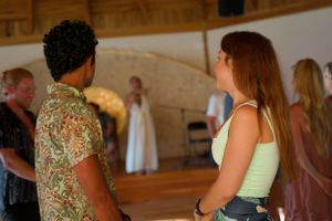 People conversing in a wooden dome space with natural light streaming in.