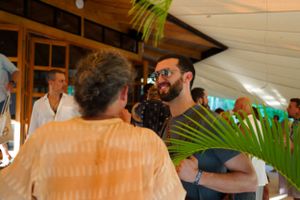 Casual social interaction in an indoor-outdoor space with tropical plants.