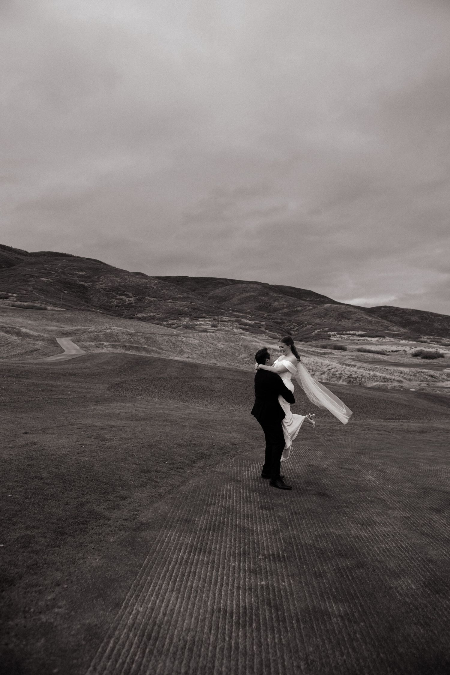 Groom spins bride around on gold course