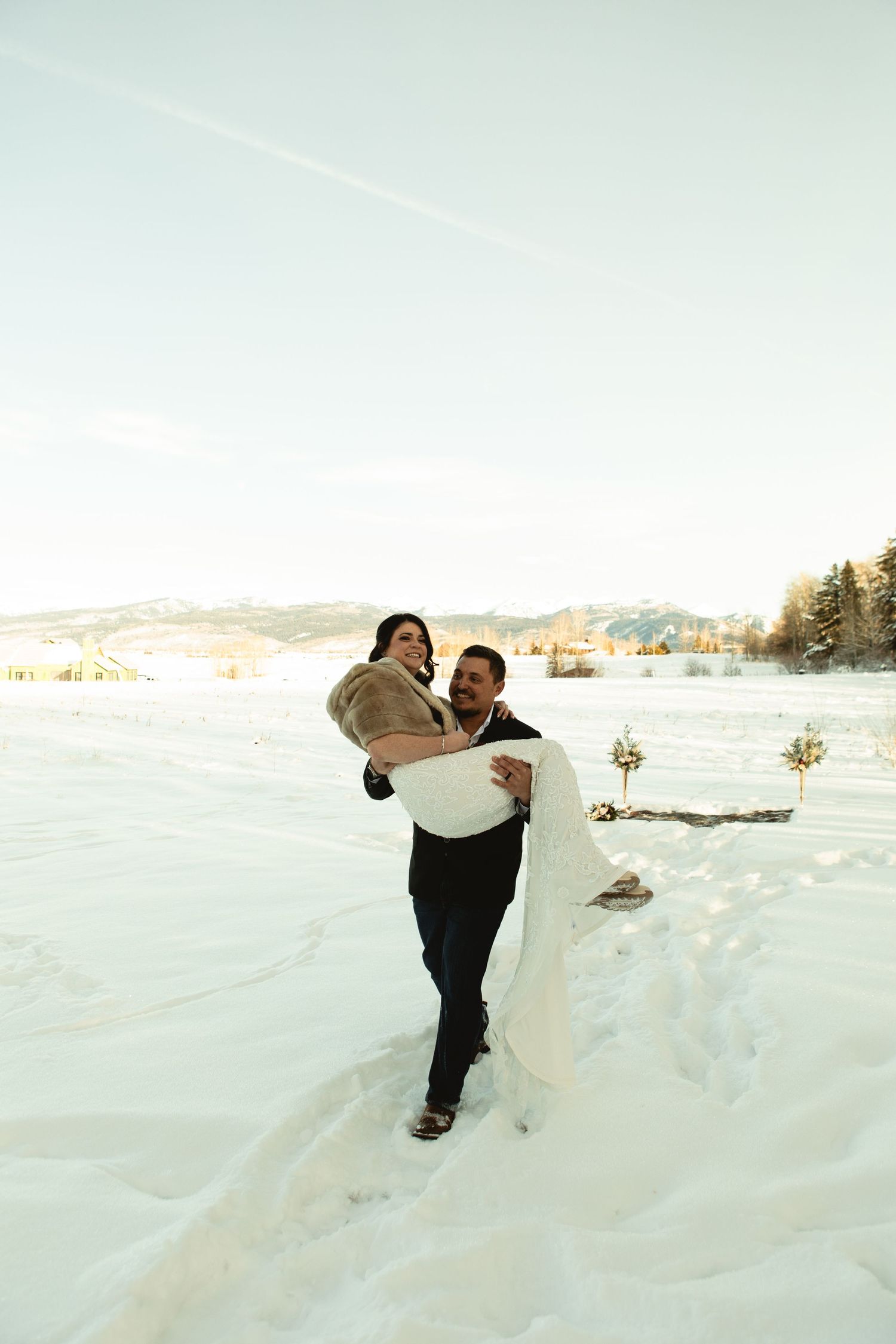 groom carries his bride away after eloping in victor idaho