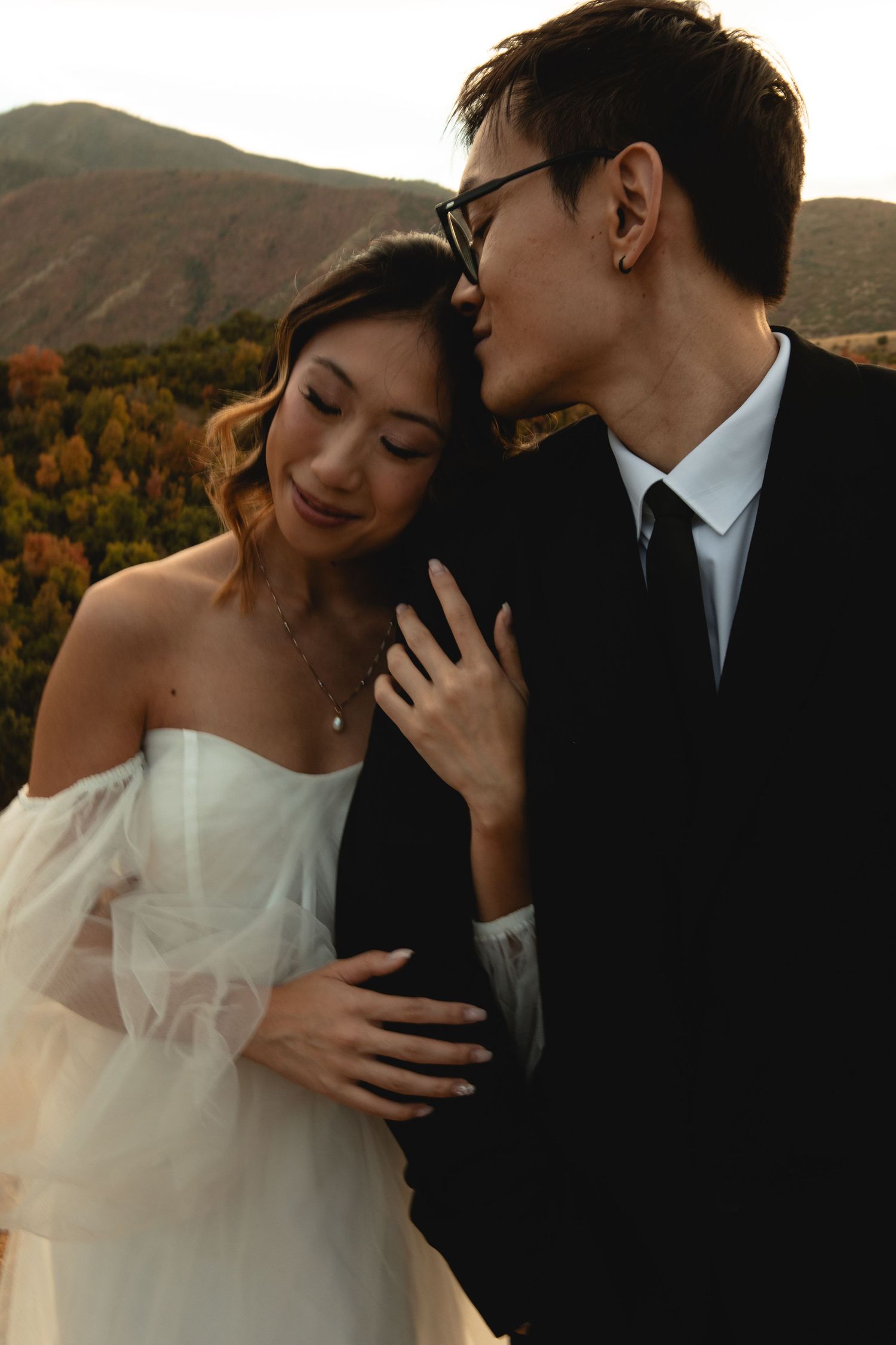 Groom kisses bride on head