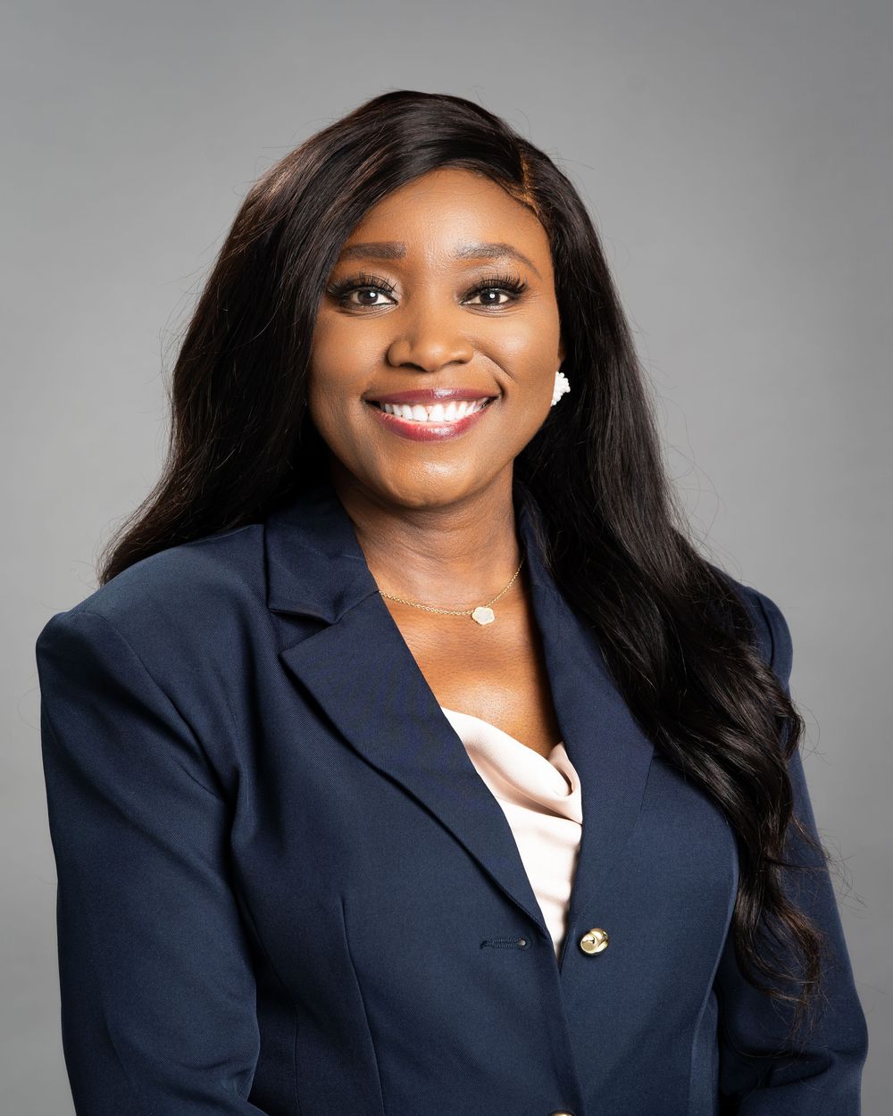 Professional headshots in navy blazer against grey studio background.