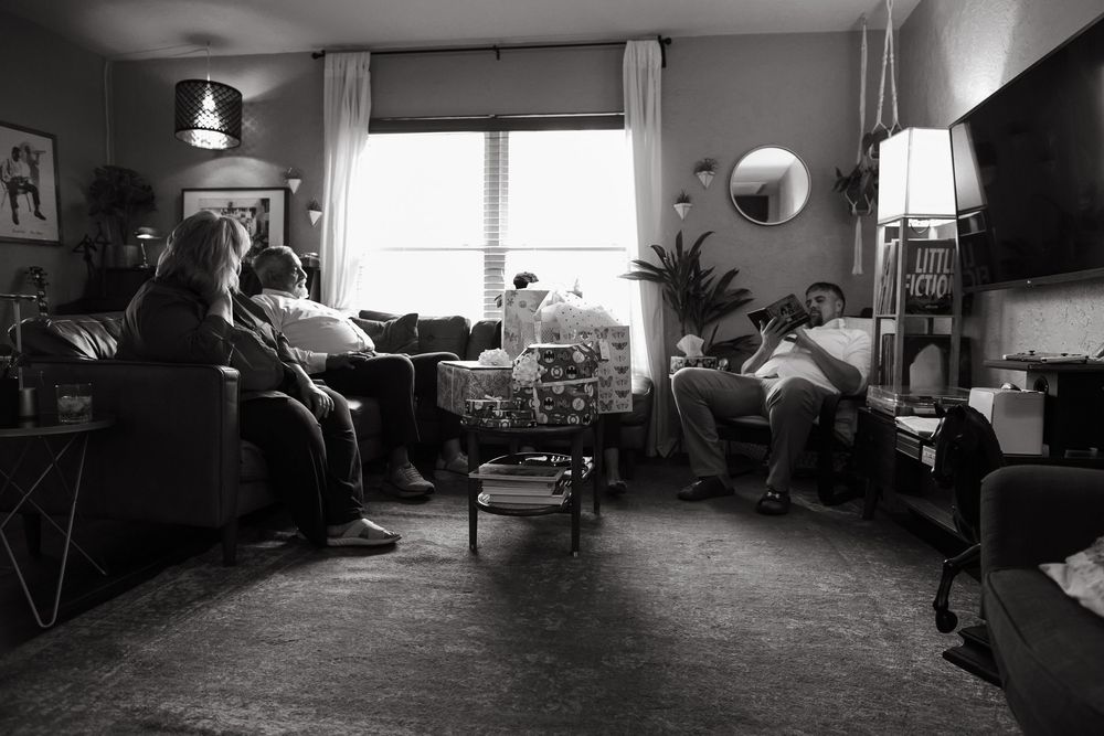 A series of black and white photographs showing interior living room spaces arranged in a horizontal panoramic layout.