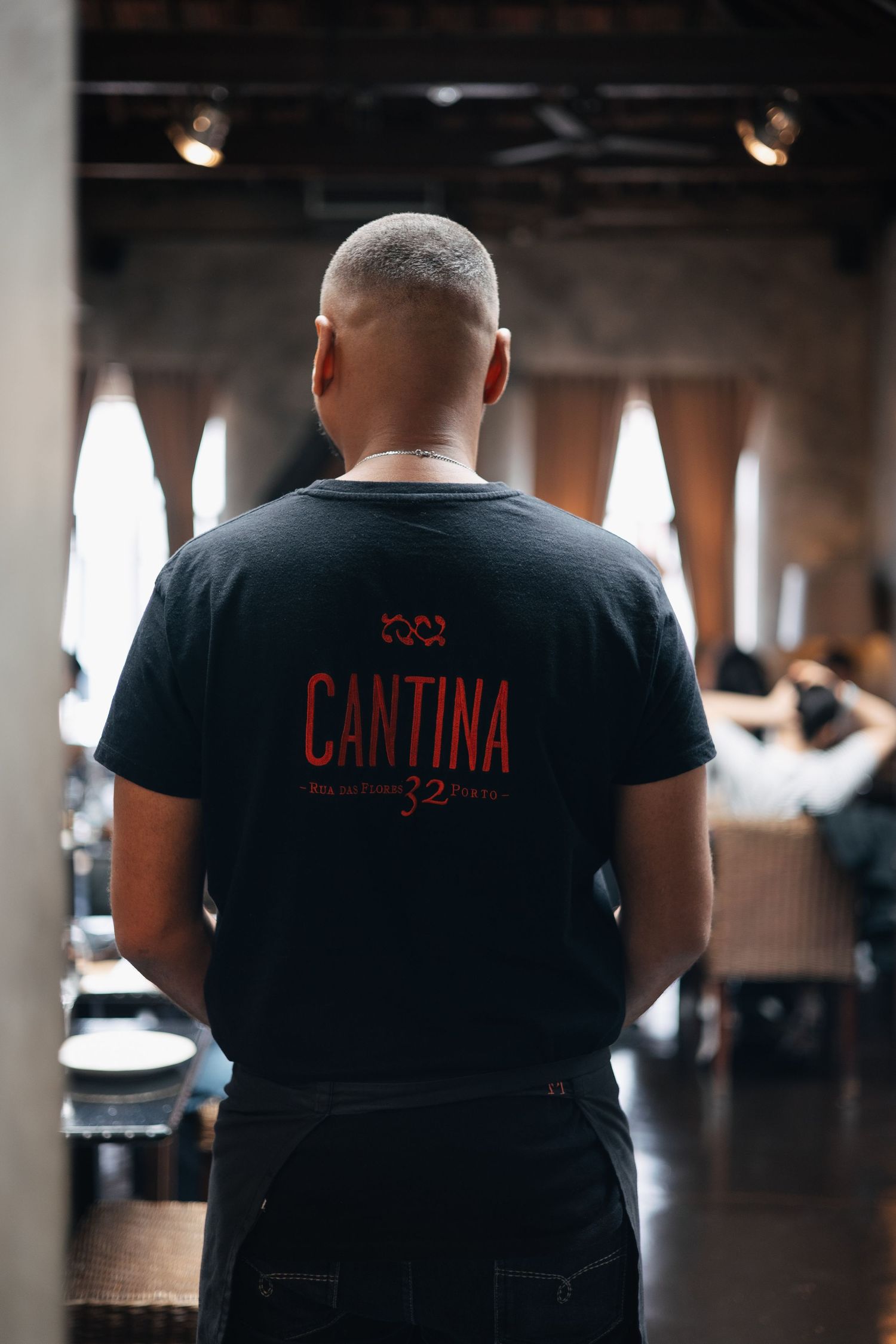 Restaurant staff wearing black t-shirts with 'Cantina' text printed on the back.