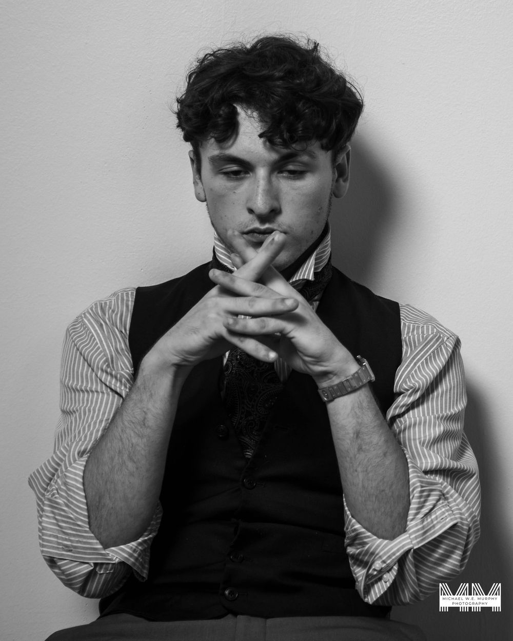 A series of black and white portraits showing a person in a striped shirt making various contemplative poses.